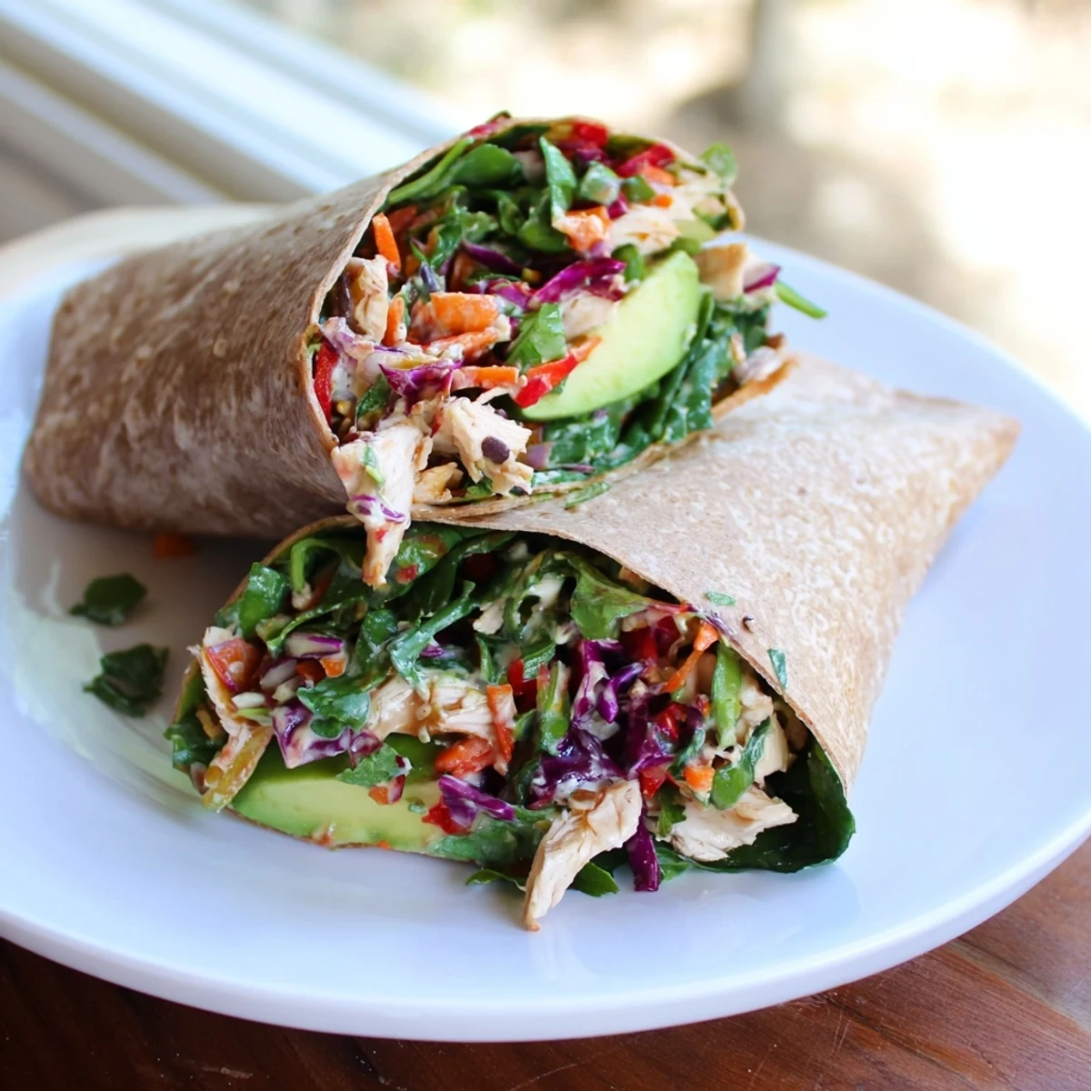 Golden-brown poppy-inspired chicken salad wraps ready to eat, featuring fresh avocado and bright veggies.