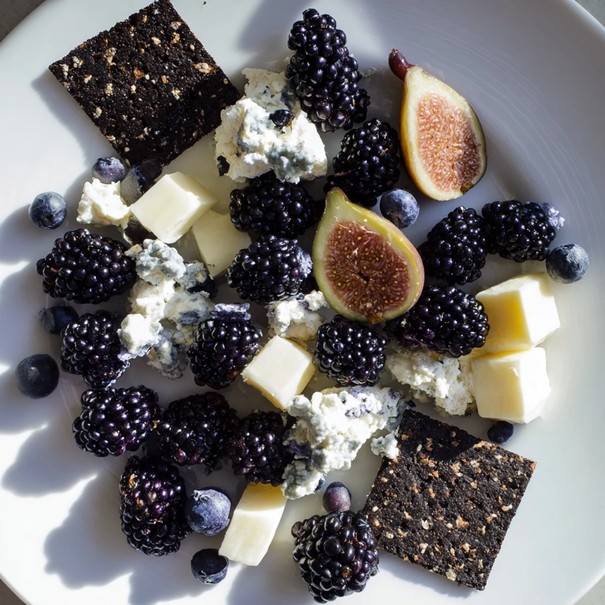 This Deep Indigo Midnight Sky cheese board arrangement features figs, goat cheese, and black crackers for an elegant appetizer.