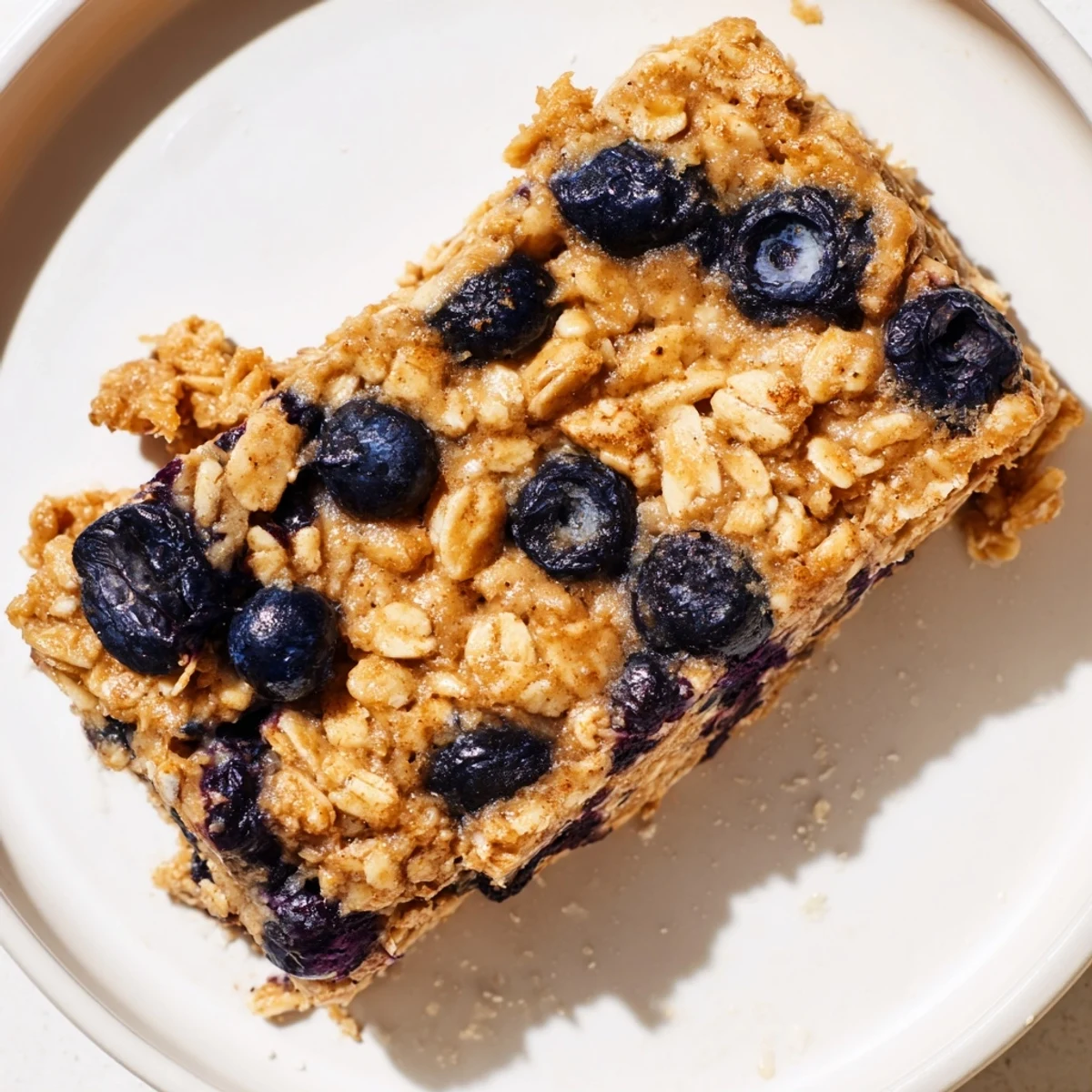 Freshly baked Blueberry Banana Oatmeal Protein Bars with visible juicy berries and golden edges.
