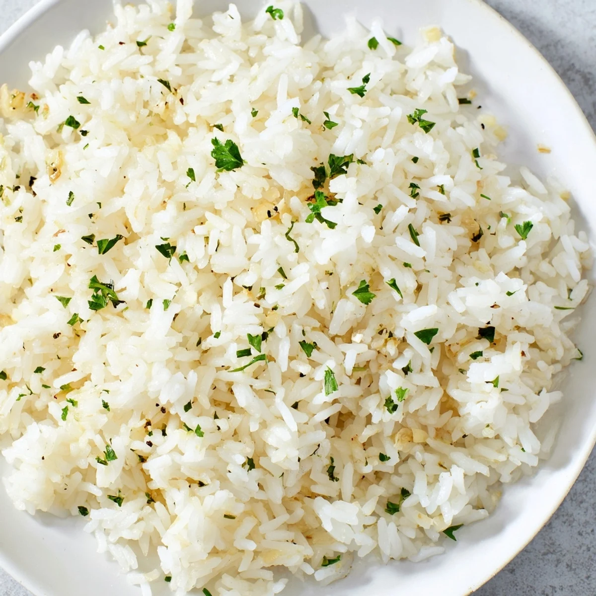 Fluffy and golden Garlic Butter Rice, garnished with parsley, a delightful side for any dinner tonight.
