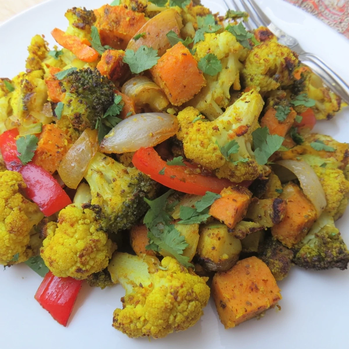 Savory Anti-Inflammatory Turmeric Roasted Vegetables served warm over fluffy quinoa, ideal for a healthy vegan dinner.