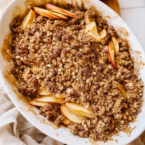 Golden, bubbling, warm rustic apple and cinnamon crumble, perfect with vanilla ice cream, ready to serve.