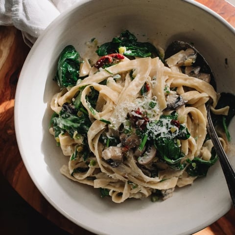 Steaming bowl of One-Pot Creamy Tuscan Garlic Herb Pasta, topped with fresh basil and Parmesan.