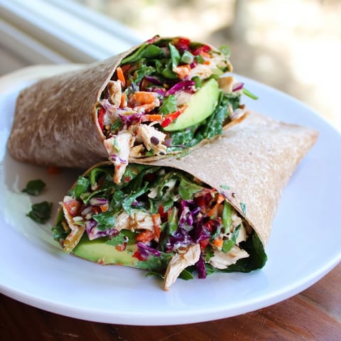 Golden-brown poppy-inspired chicken salad wraps ready to eat, featuring fresh avocado and bright veggies.