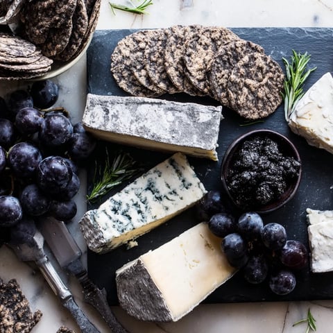 Elegant Monochrome Gray Stone Cheese Board, complete with rich cheese, crackers, and fruits for a stunning appetizer.