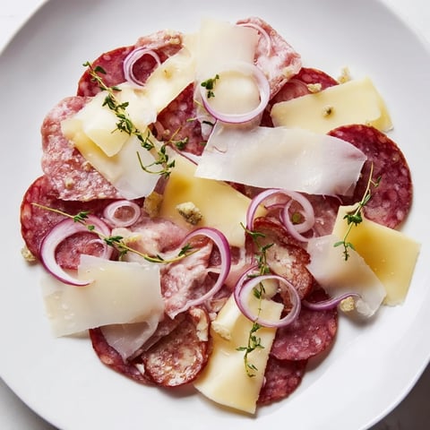 A delectable Burlap & Lace charcuterie board overflows with savory meats and delicate, shaved cheeses ready to enjoy.