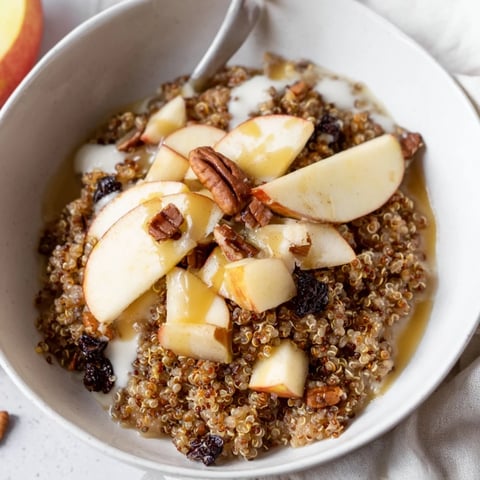 Steaming Apple Cinnamon Quinoa Bowl, a cozy breakfast with warm apples and a cinnamon aroma.