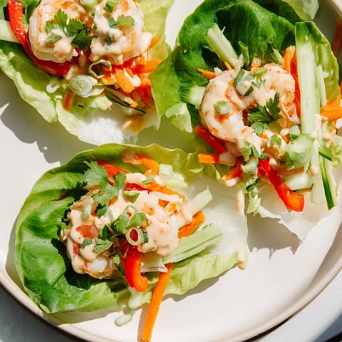 Vibrant shrimp lettuce cups, filled with colorful vegetables and succulent, cooked shrimp ready to enjoy.