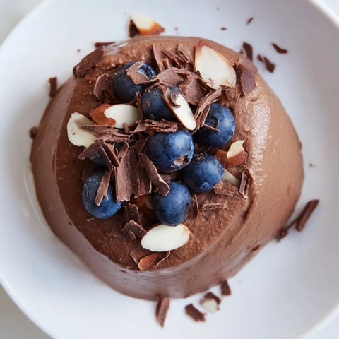 Silky chocolate avocado mousse, topped with fresh berries, ready for a delicious dessert.