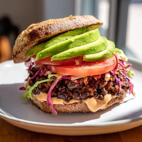 A juicy Zesty Black Bean Burger on a toasted bun, topped with lettuce and red onion.