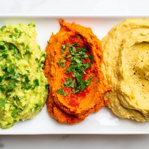 Three delightful dips in a line, the Dip Trio appetizer, with colorful textures and flavors for sharing.