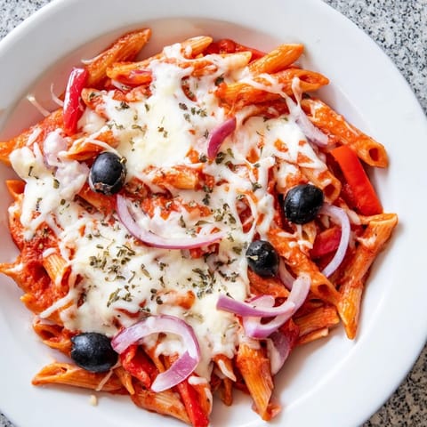 A steaming bowl of flavorful One-Pot Pizza Pasta Express, with fresh herbs and colorful bell peppers.