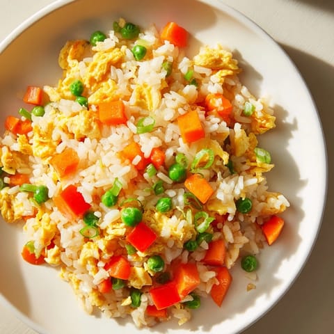 Golden Egg Fried Rice with visible peas, carrots, and a savory soy sauce glaze.