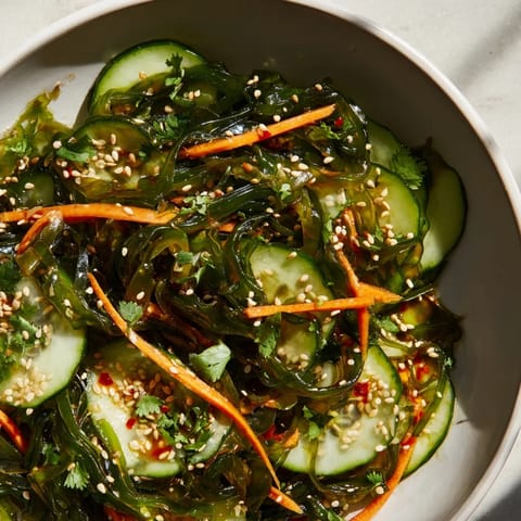 Serving suggestion for Seaweed Salad garnished with toasted sesame seeds and cilantro, perfect as a refreshing vegan appetizer or light side dish.