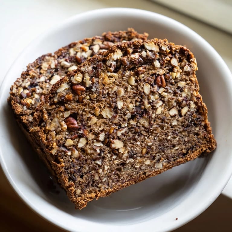 A close-up of a freshly baked Nutty Whole Wheat Loaf Bread, showcasing varied nut pieces.