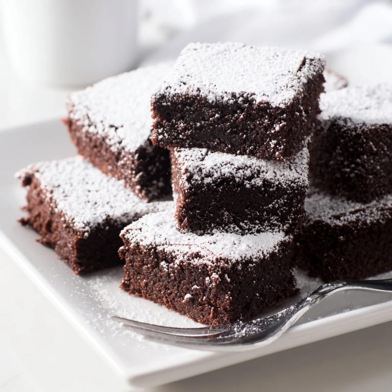 Homemade brownie squares, baked until perfect, and sprinkled with powdered sugar for extra sweetness.