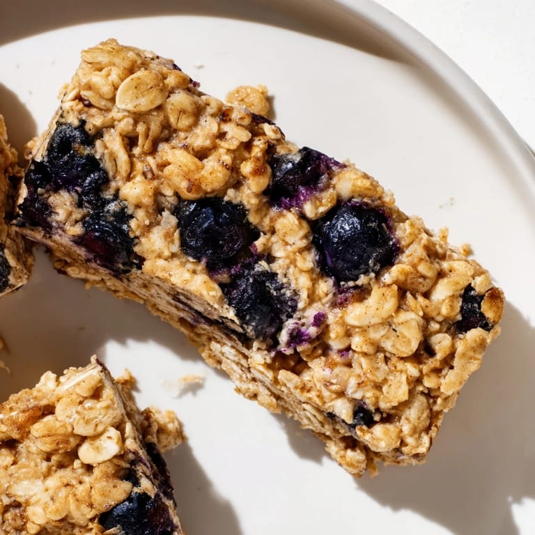 A close-up shot of homemade Blueberry Banana Oatmeal Protein Bars showing a tempting cross-section.