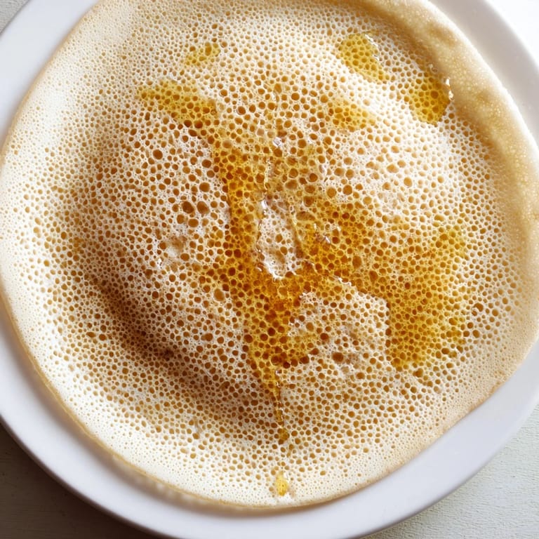 Golden, bubbly Moroccan Baghrir, the perfect honeycomb-textured pancake, served warm and sweet.