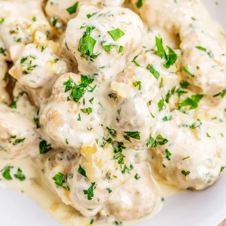 Tender bite-sized chicken pieces in a skillet with Creamy Garlic Chicken Bites, steam rising from the sauce.
